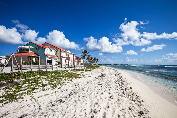caribbean-beach-with-palm-trees-and-houses-istock_000011676936_large-2