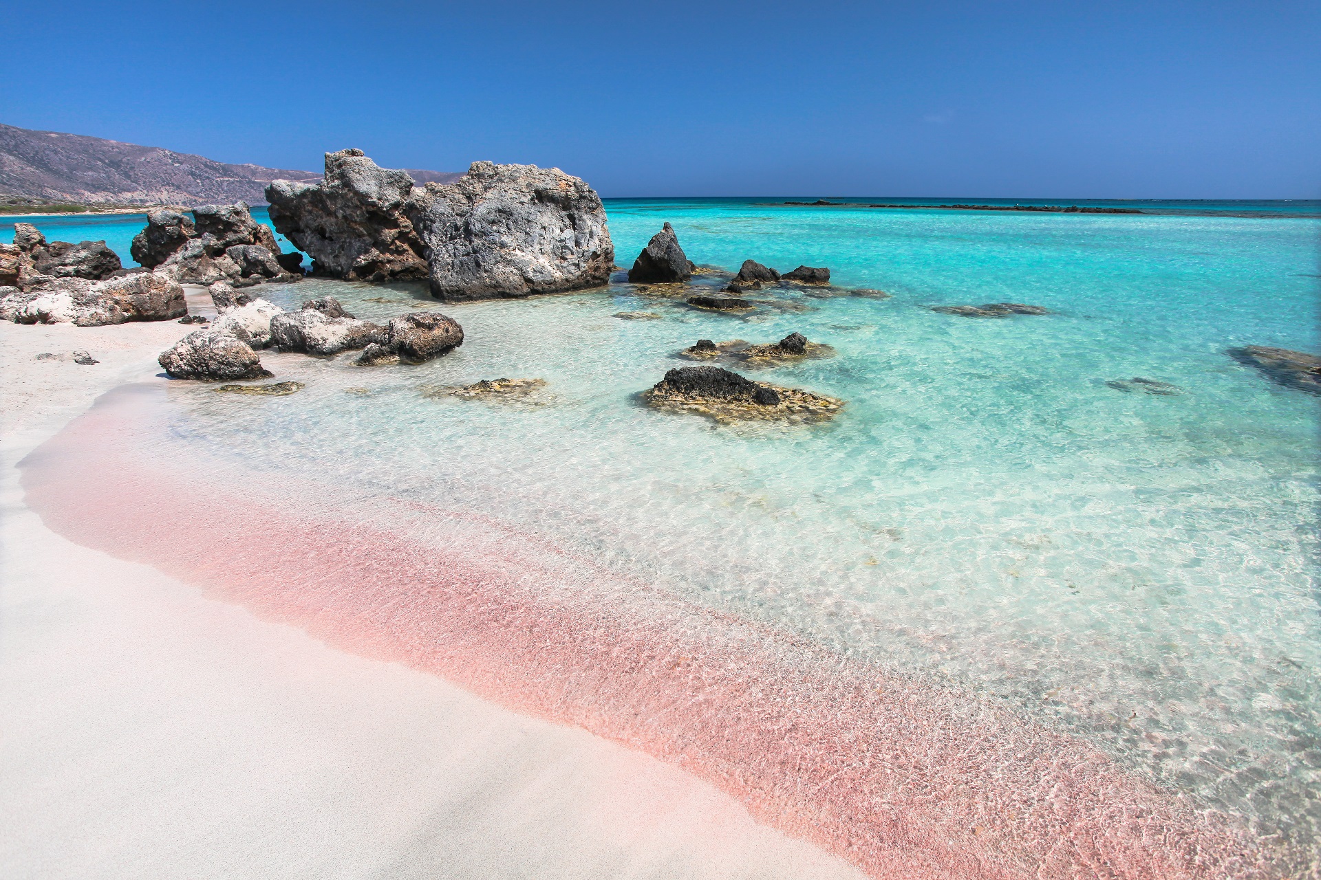 Rosafarbener Sand und Felsen am Strand Elafonisi auf Kreta, Griechenland